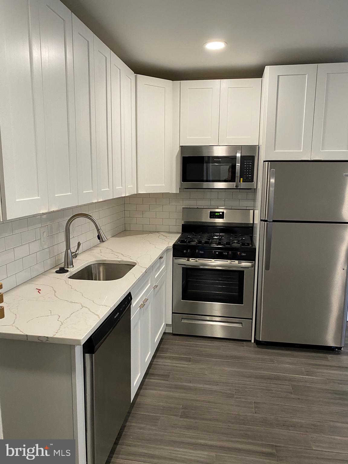 135 South 19th Street, Unit 1007 Philadelphia, PA 19103 - Photo 3 of 13 a kitchen with granite countertop a sink and a stove top oven