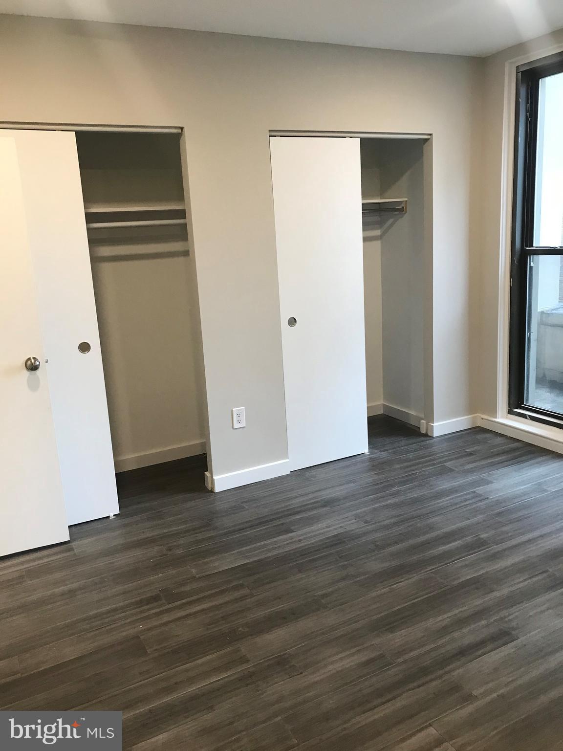 135 South 19th Street, Unit 1007 Philadelphia, PA 19103 - Photo 5 of 13 an empty room with wooden floor and closet