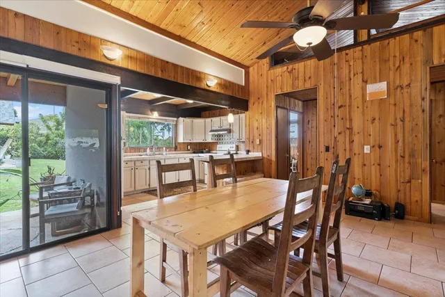 a dining hall with stainless steel appliances kitchen island granite countertop a table and chairs