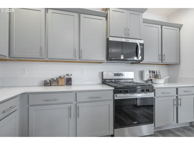 a kitchen with granite countertop white cabinets and stainless steel appliances