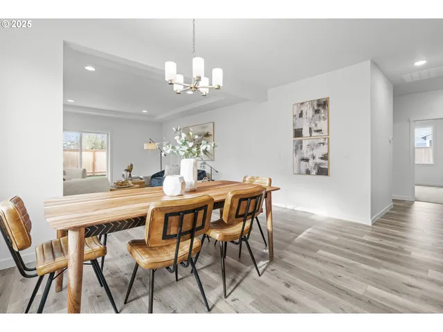 a dining room with furniture a chandelier and wooden floor