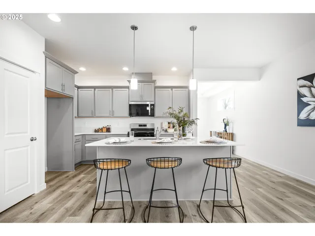 a kitchen with stainless steel appliances a kitchen island a stove a table and chairs in it