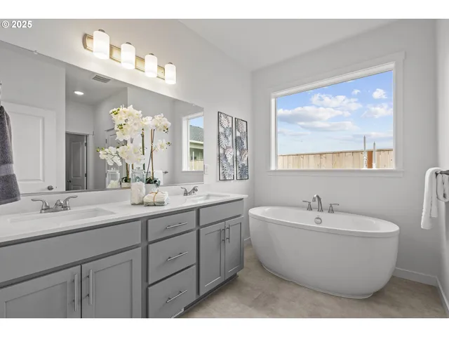 a spacious bathroom with a double vanity sink mirror and bathtub