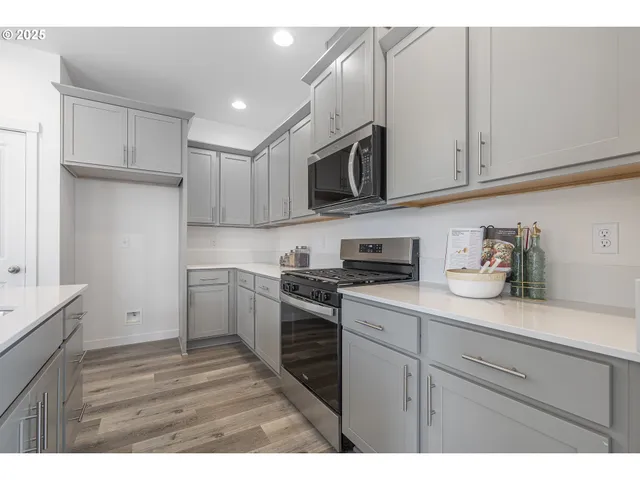 a kitchen with cabinets stainless steel appliances and sink