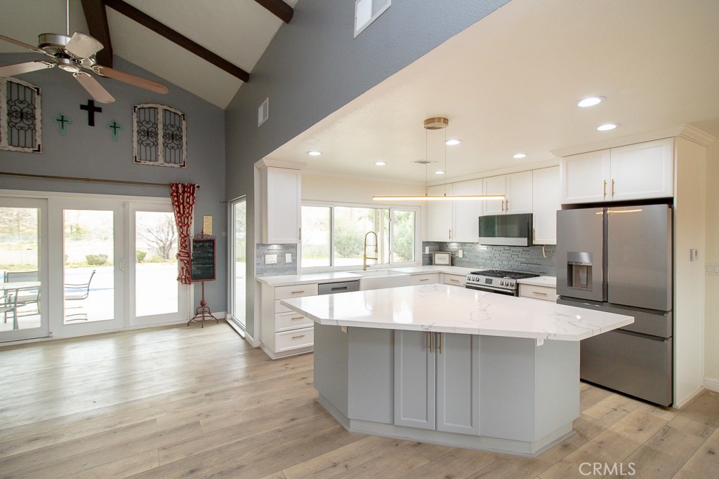 20376 Tonawanda Road Apple Valley, CA 92307 - Photo 19 of 67 a large kitchen with kitchen island a large counter top space a sink stainless steel appliances and cabinets