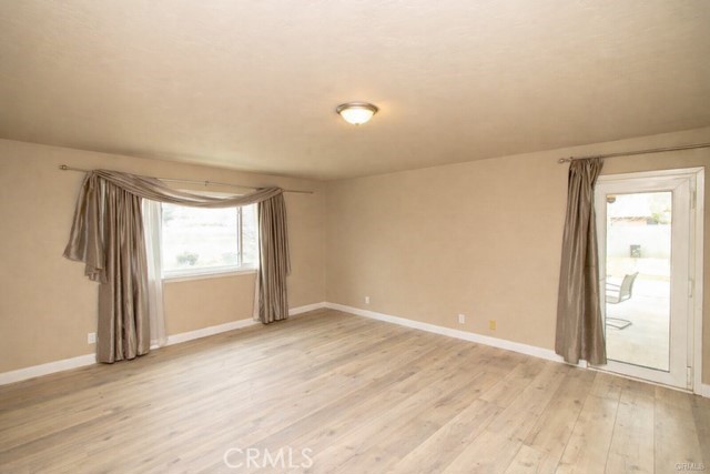 20376 Tonawanda Road Apple Valley, CA 92307 - Photo 25 of 67 an empty room with wooden floor and windows