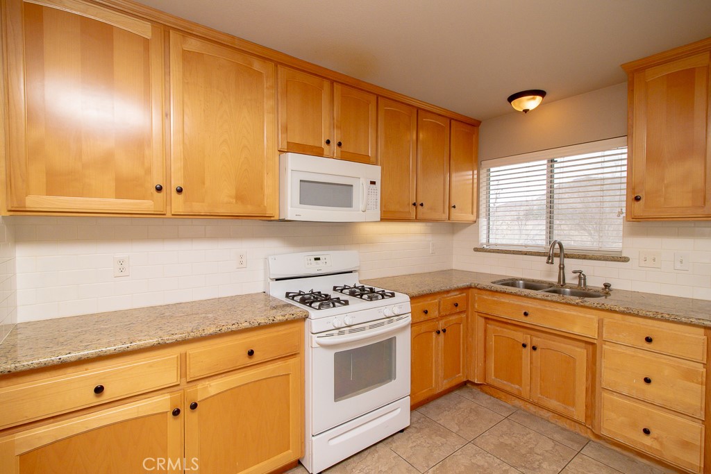 20376 Tonawanda Road Apple Valley, CA 92307 - Photo 55 of 67 a kitchen with cabinets appliances a sink and a window