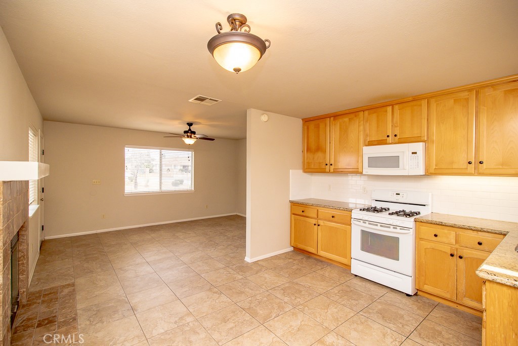 20376 Tonawanda Road Apple Valley, CA 92307 - Photo 56 of 67 a kitchen with a stove a sink and a refrigerator