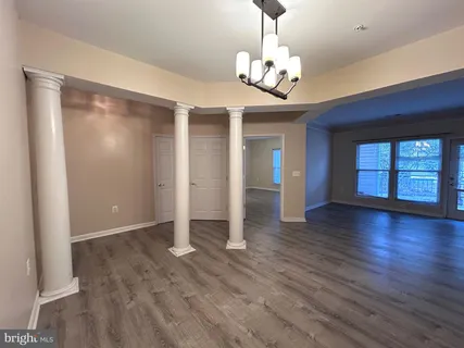 a view of a livingroom with a chandelier wooden floor and chandelier