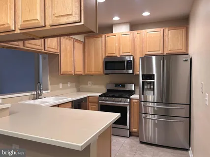 a kitchen with stainless steel appliances a refrigerator sink and microwave