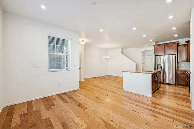a kitchen with stainless steel appliances granite countertop a sink a stove and a refrigerator