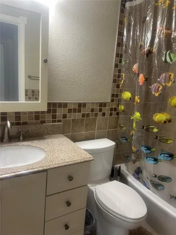 a bathroom with a granite countertop toilet sink and mirror