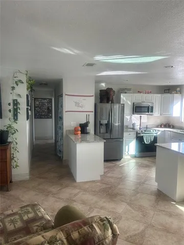 a view of a kitchen with furniture and refrigerator