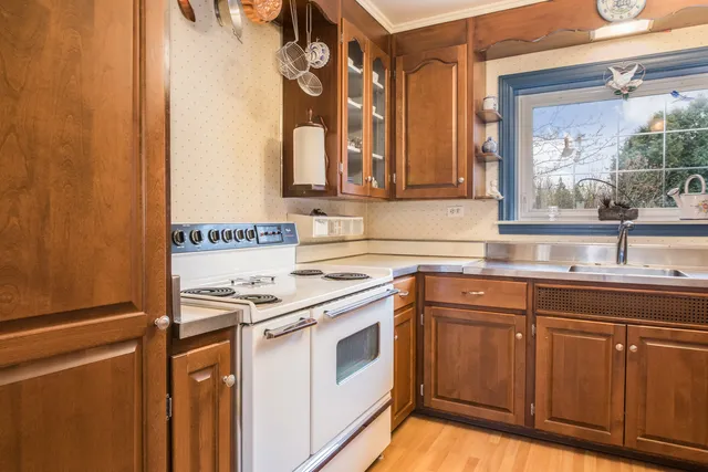 a kitchen with stainless steel appliances granite countertop a sink and a stove next to a window
