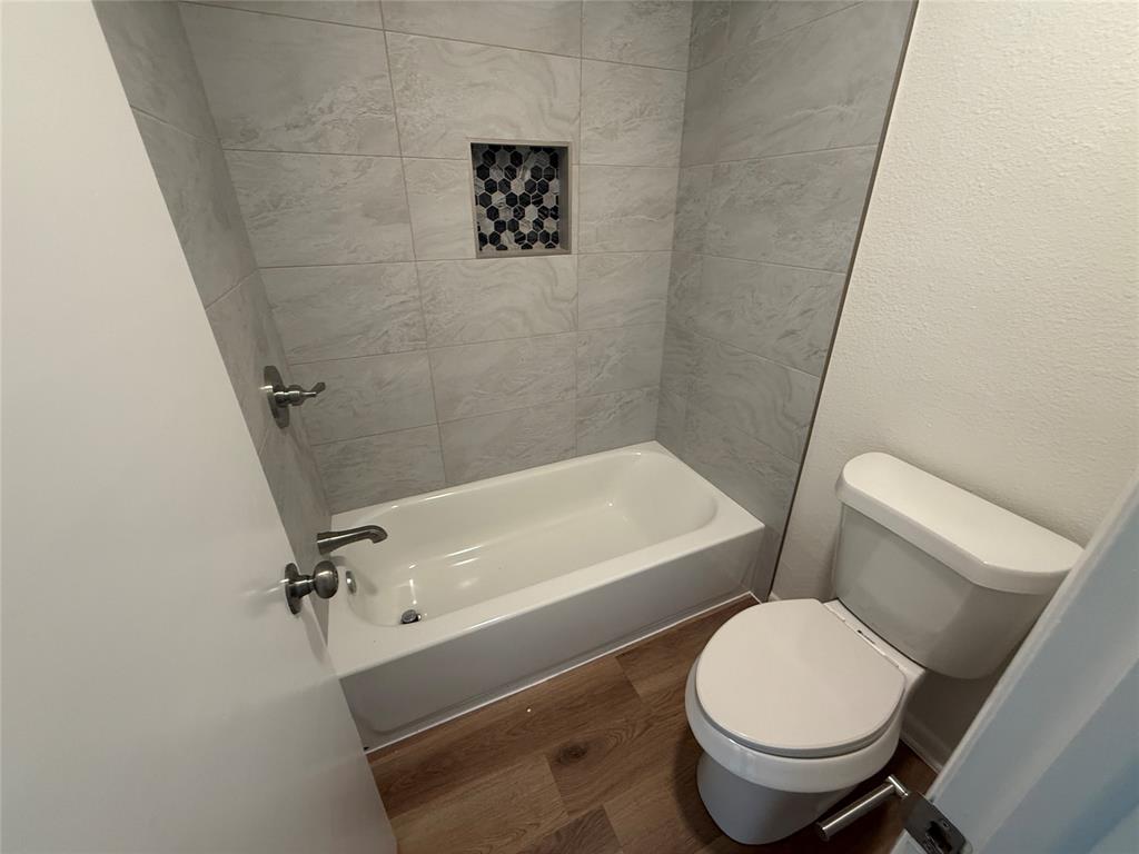 1102 Chilton Street Weatherford, TX 76086 - Photo 18 of 28 a white toilet sitting next to a bath tub