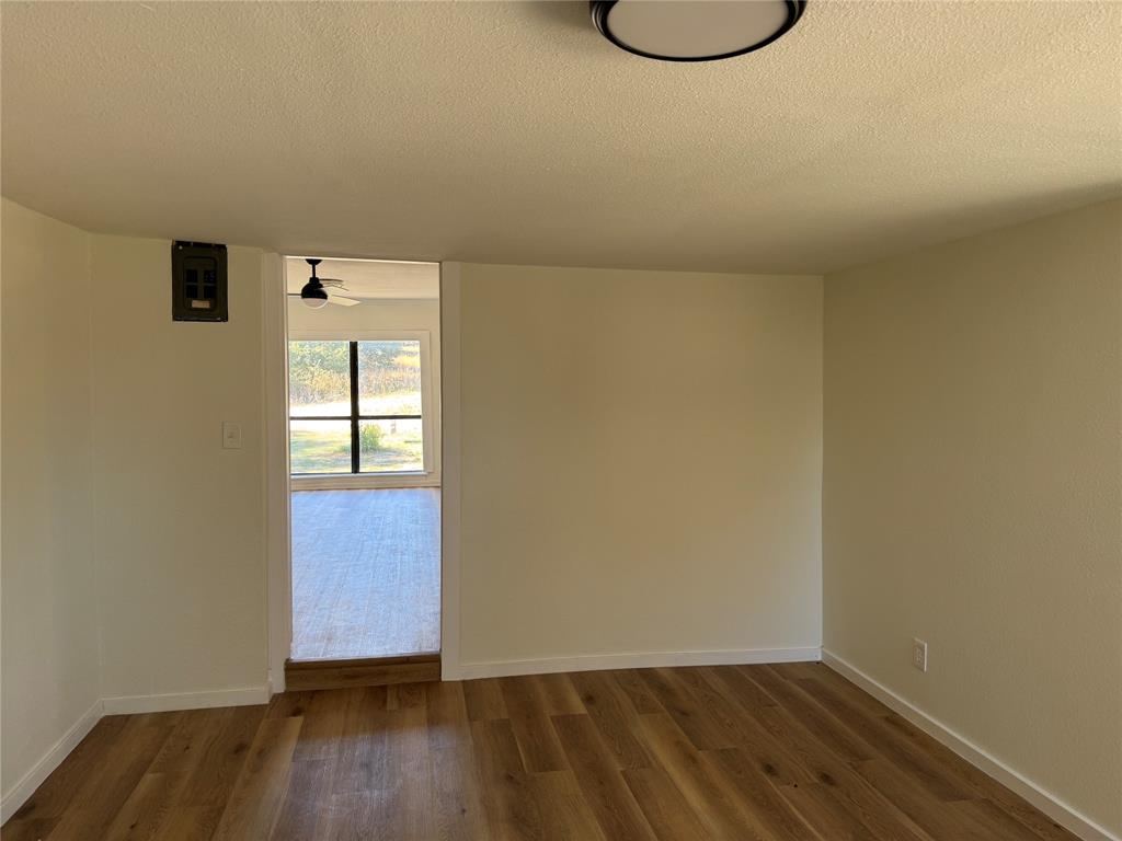 1102 Chilton Street Weatherford, TX 76086 - Photo 21 of 28 a view of an empty room with wooden floor and a window