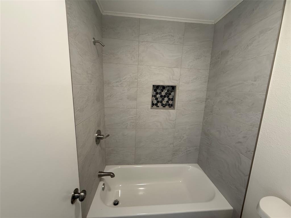 1102 Chilton Street Weatherford, TX 76086 - Photo 24 of 28 a bath tub sitting next to a white toilet