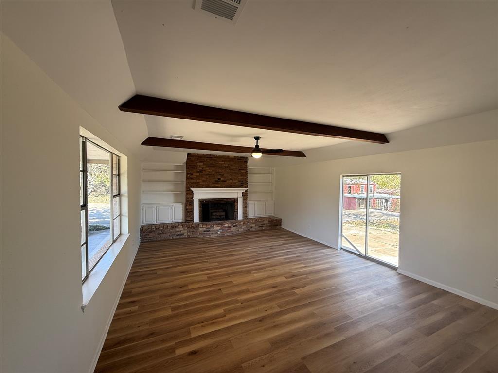 1102 Chilton Street Weatherford, TX 76086 - Photo 3 of 28 wooden floor in an empty room with a fireplace