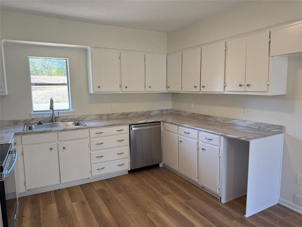 1102 Chilton Street Weatherford, TX 76086 - Photo 9 of 28 a kitchen with granite countertop white cabinets and sink