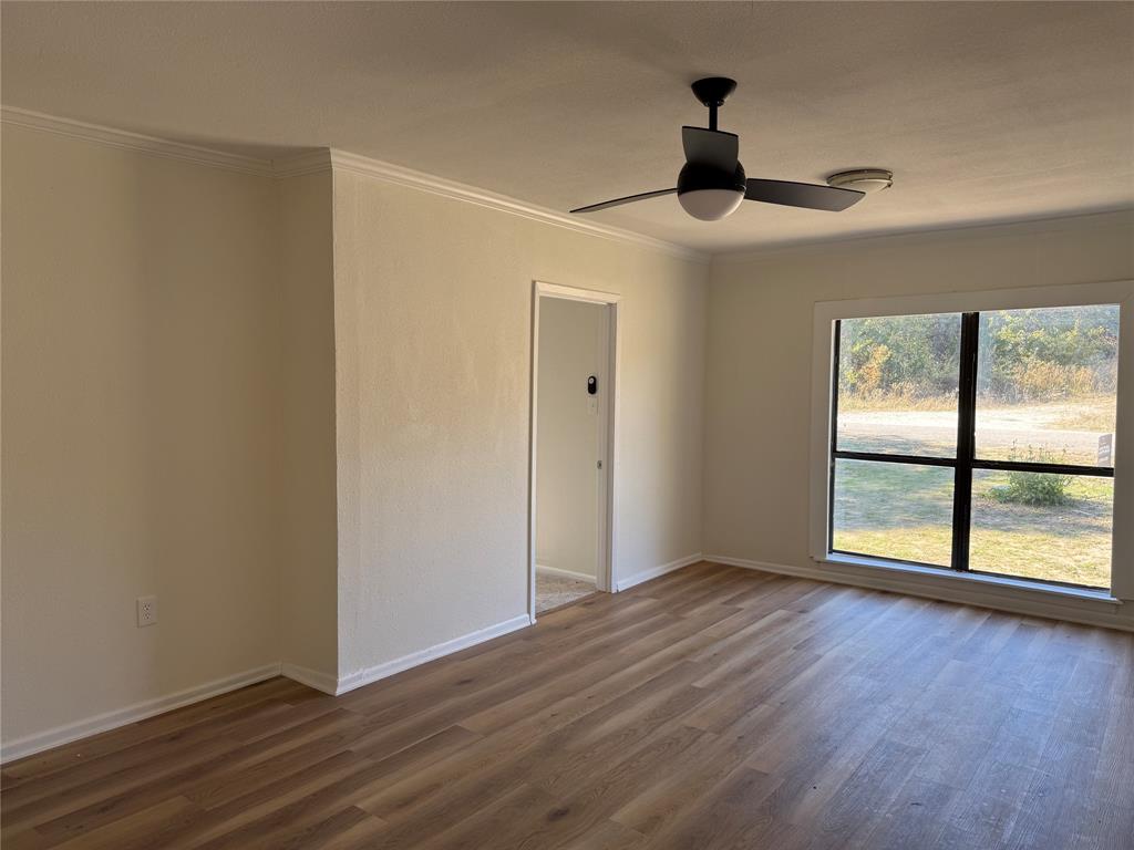 1102 Chilton Street Weatherford, TX 76086 - Photo 10 of 28 wooden floor in an empty room with a window