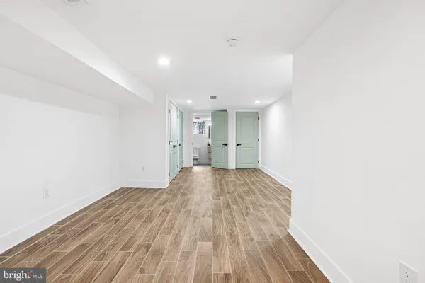 a view of empty room with wooden floor