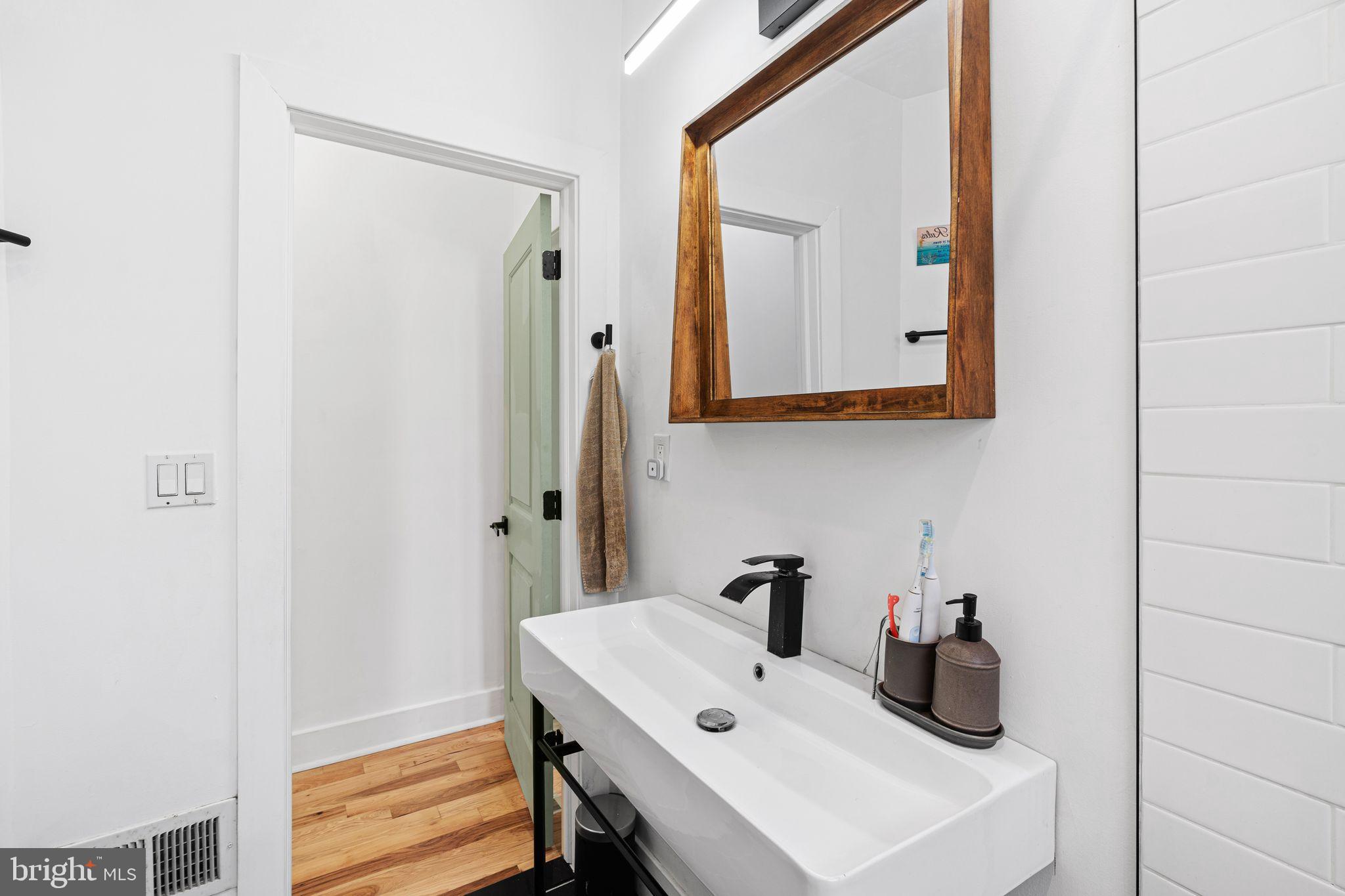 2937 Nicholas Street Philadelphia, PA 19121 - Photo 23 of 33 a bathroom with a sink and a mirror