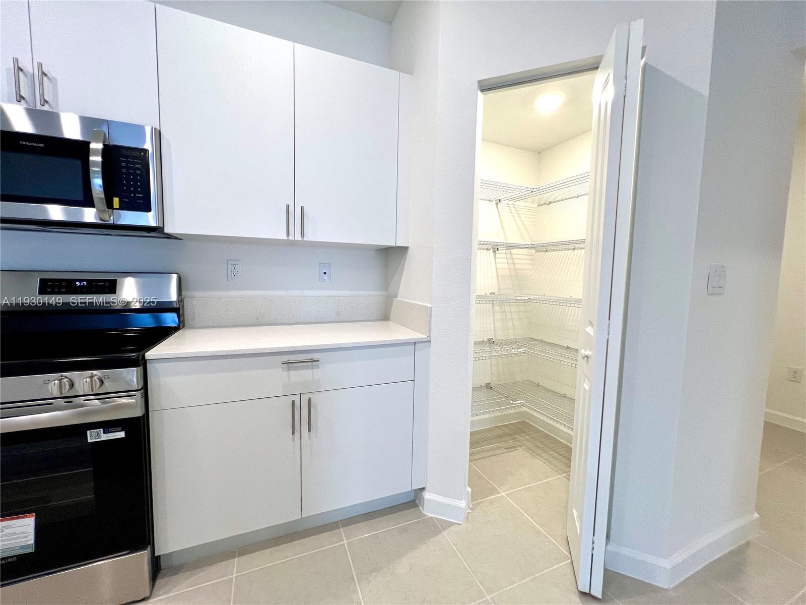 17376 Southwest 285th Street, Unit 1 Homestead, FL 33030 - Photo 11 of 32 a kitchen with a refrigerator and a stove top oven