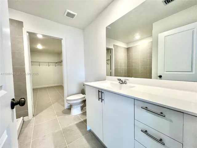 a bathroom with a double vanity sink toilet and shower