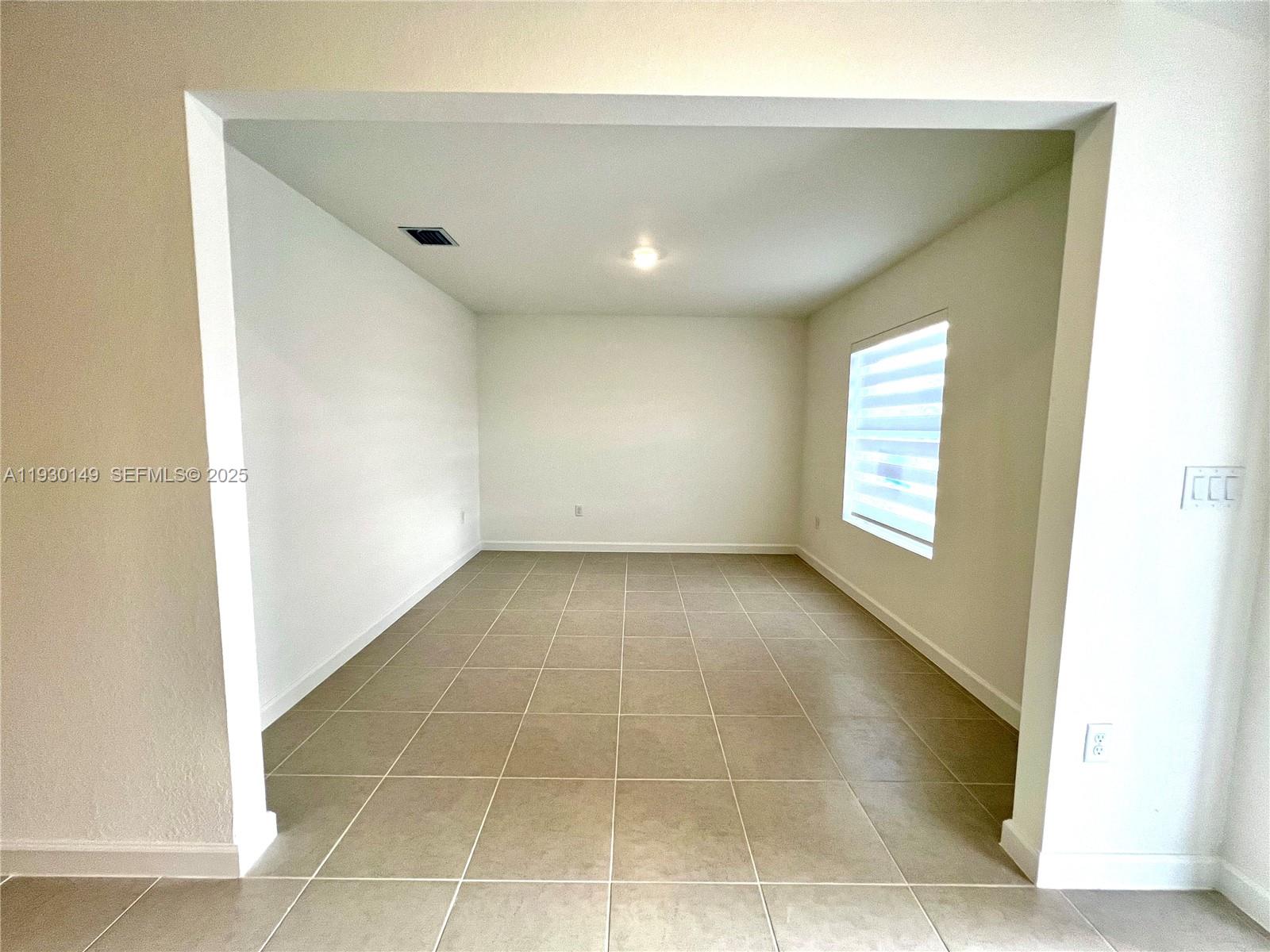 17376 Southwest 285th Street, Unit 1 Homestead, FL 33030 - Photo 4 of 32 a view of an empty room with a window