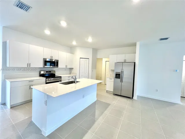 a kitchen with stainless steel appliances a refrigerator sink and microwave