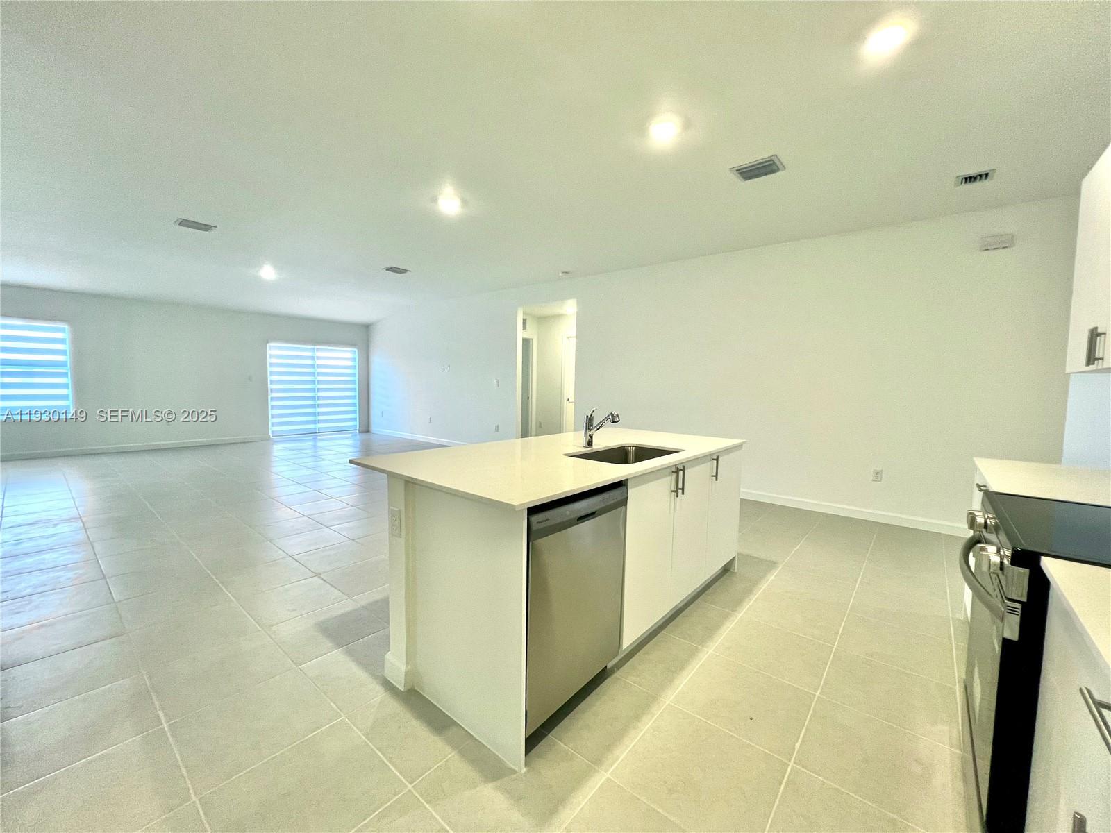 17376 Southwest 285th Street, Unit 1 Homestead, FL 33030 - Photo 9 of 32 a large white bathroom with a sink a toilet and a mirror