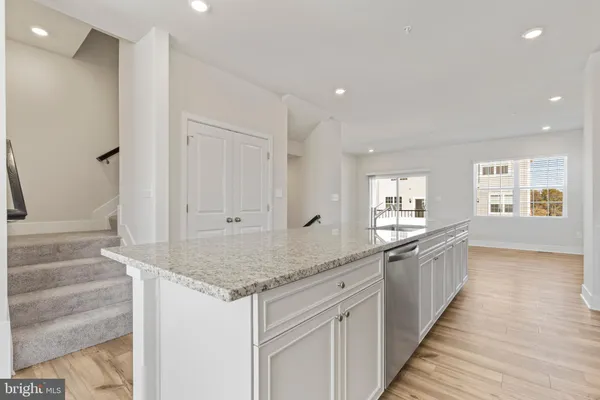 a kitchen with granite countertop white cabinets and sink
