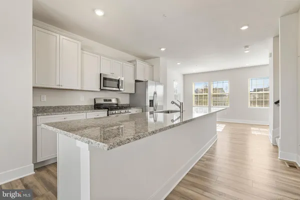 a kitchen with granite countertop a sink a counter top space and cabinets