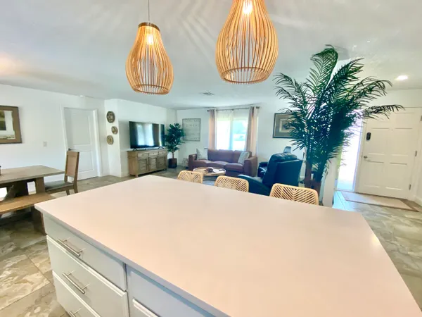 a bed sitting in a spacious bedroom next to a window and a chandelier
