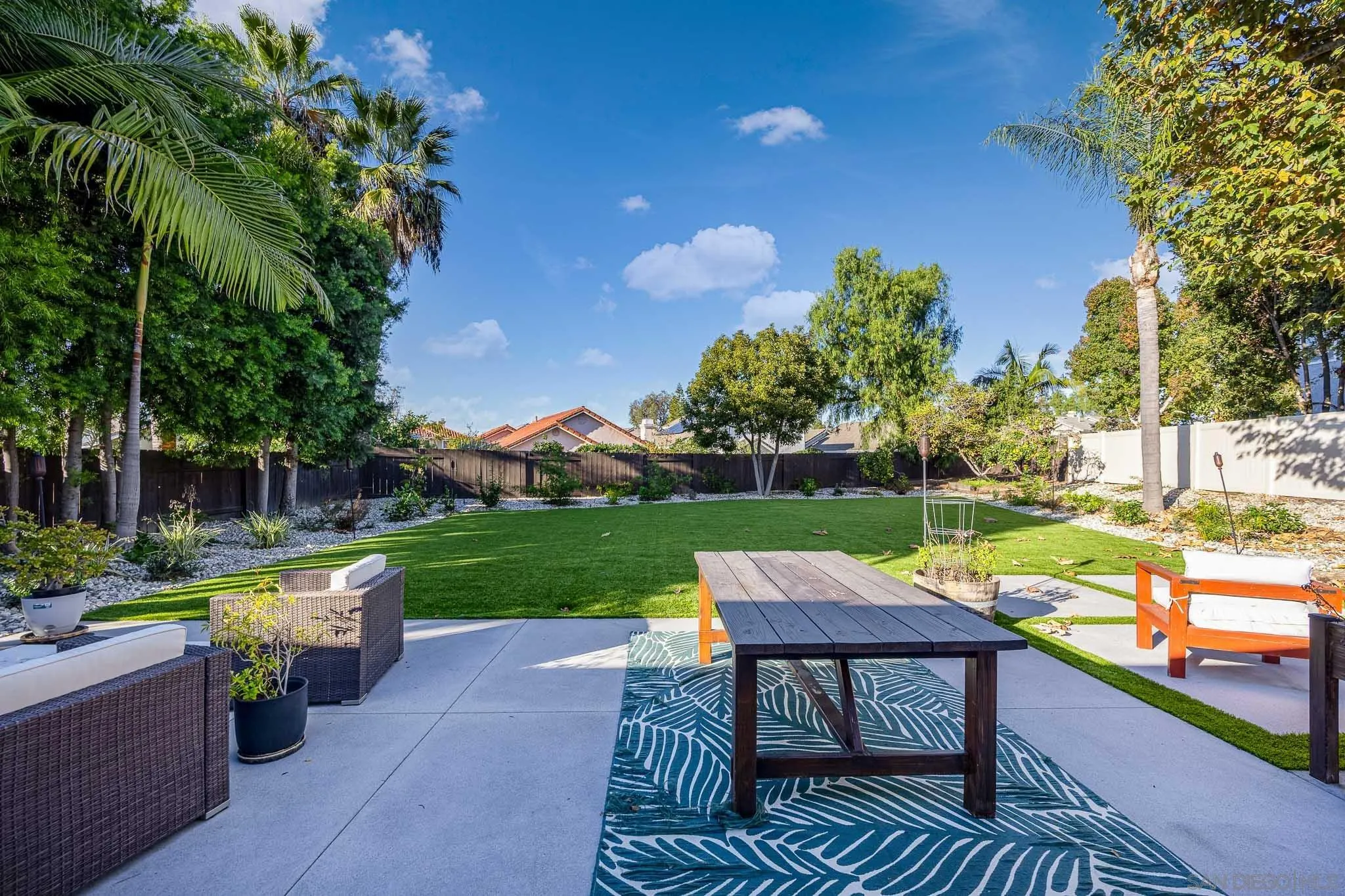5358 Raspberry Way Oceanside, CA 92057 - Photo 18 of 31 a view of a patio with table and chairs potted plants and a palm tree