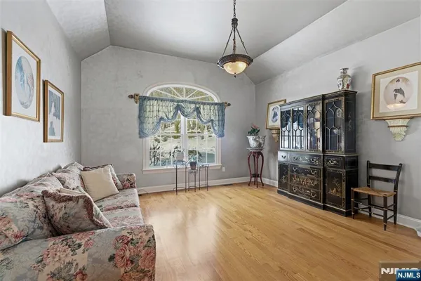 a living room with furniture a chandelier and a flat screen tv