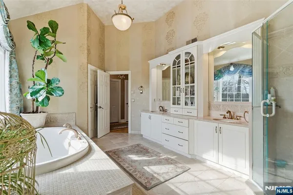 a spacious bathroom with a granite countertop tub shower and mirror