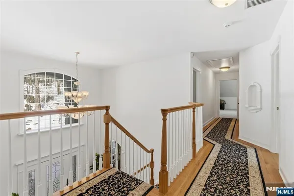 a view of a hallway with wooden floor and staircase