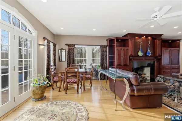 a living room with furniture a fireplace and a dining table with wooden floor