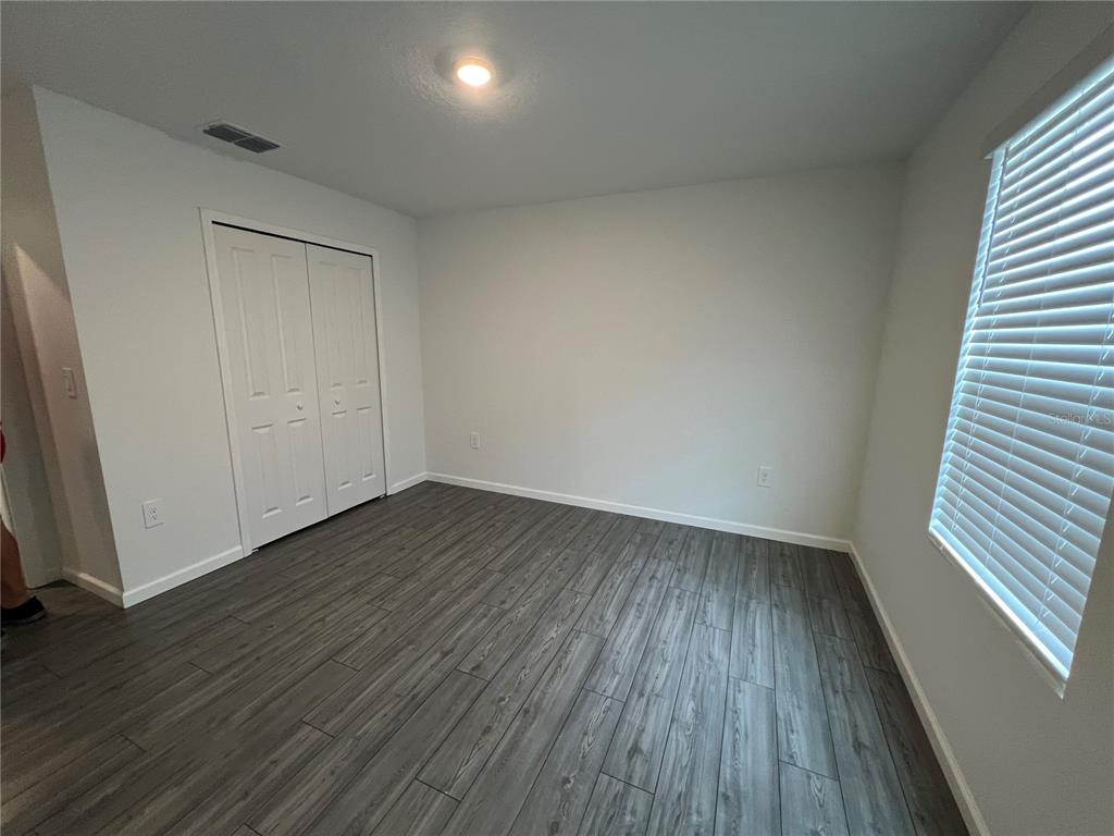 4576 Southwest 84th St Road Ocala, FL 34476 - Photo 23 of 50 a view of an empty room with wooden floor and a window