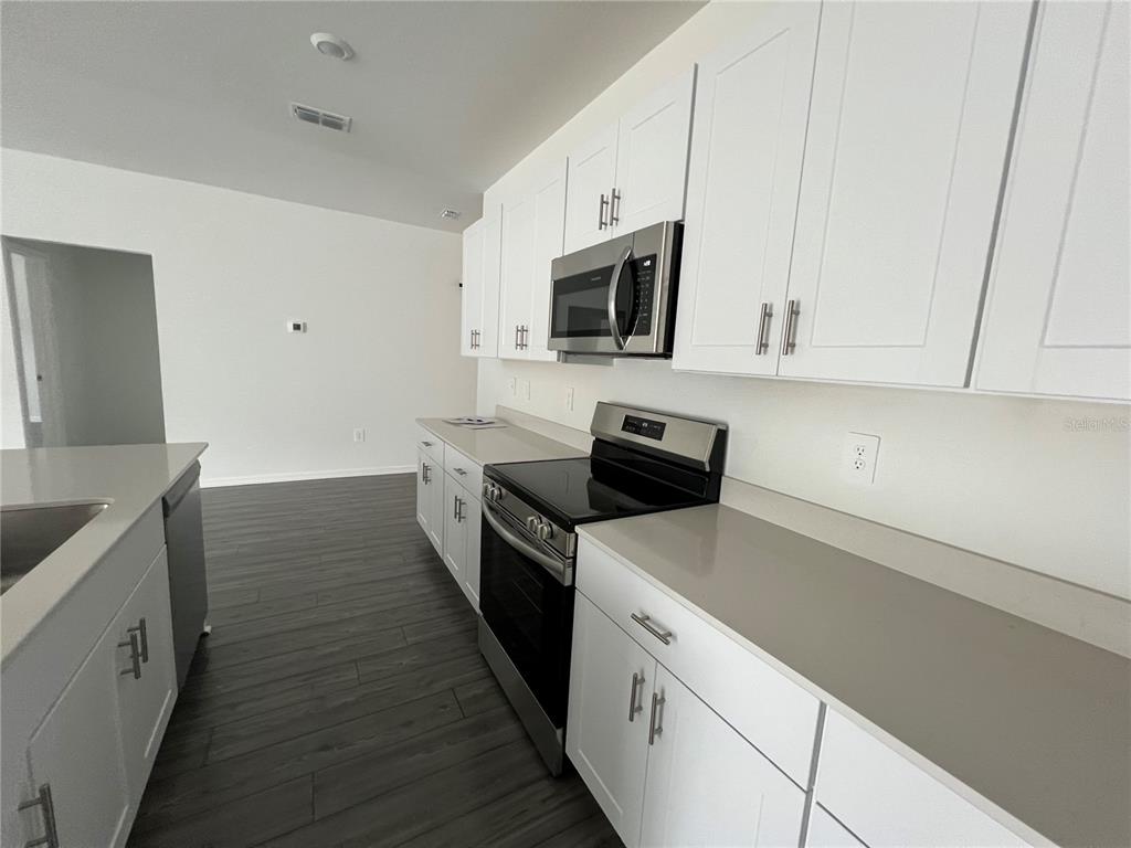 4576 Southwest 84th St Road Ocala, FL 34476 - Photo 8 of 50 a kitchen with stainless steel appliances a stove microwave and sink