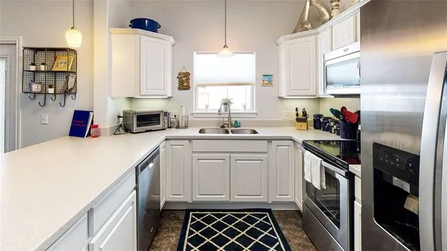 a kitchen with granite countertop a sink stainless steel appliances and cabinets