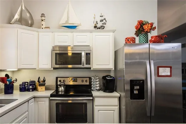 a kitchen with stainless steel appliances granite countertop a refrigerator a stove and a sink