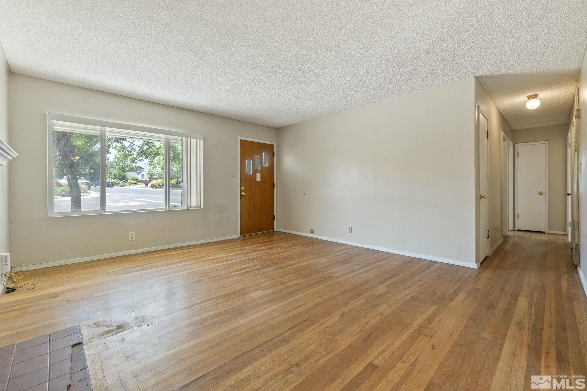 1585 University Terrace Reno, NV 89503 - Photo 8 of 32 an empty room with wooden floor and windows