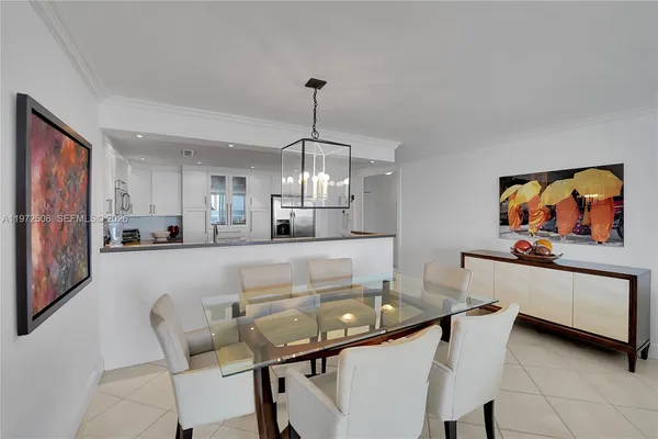 a kitchen with stainless steel appliances granite countertop a dining table chairs and a refrigerator