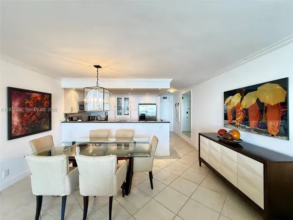 a dining hall with stainless steel appliances kitchen island granite countertop a dining table and chairs