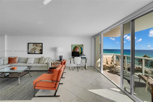 a living room with furniture and floor to ceiling window
