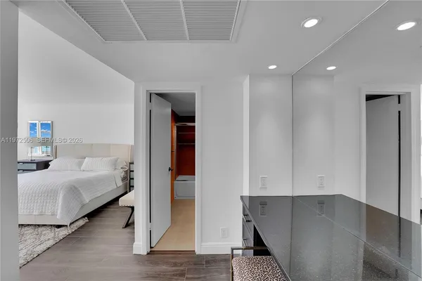 a hallway with wooden floor white walls and stairs