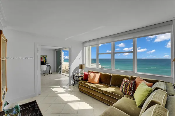 a view of a living room with furniture and floor to ceiling window