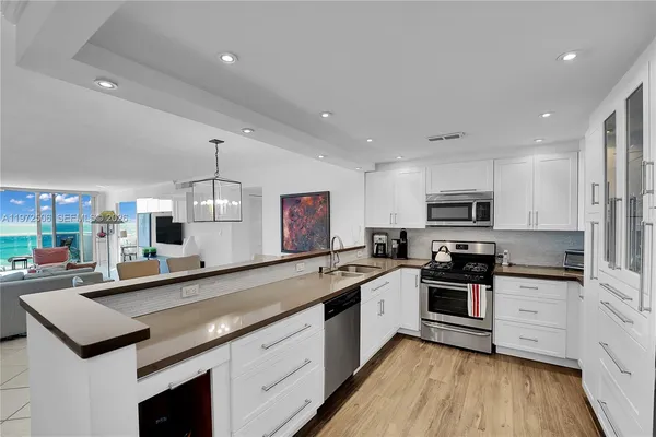 a kitchen with stainless steel appliances a sink stove and cabinets